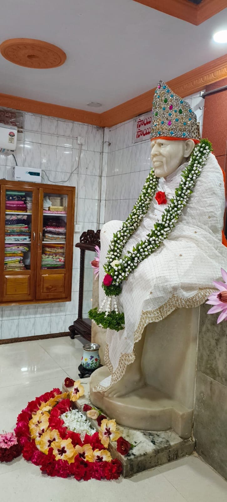 Murti in profile, wearing a white lace-bordered shawl and a jeweled silver crown