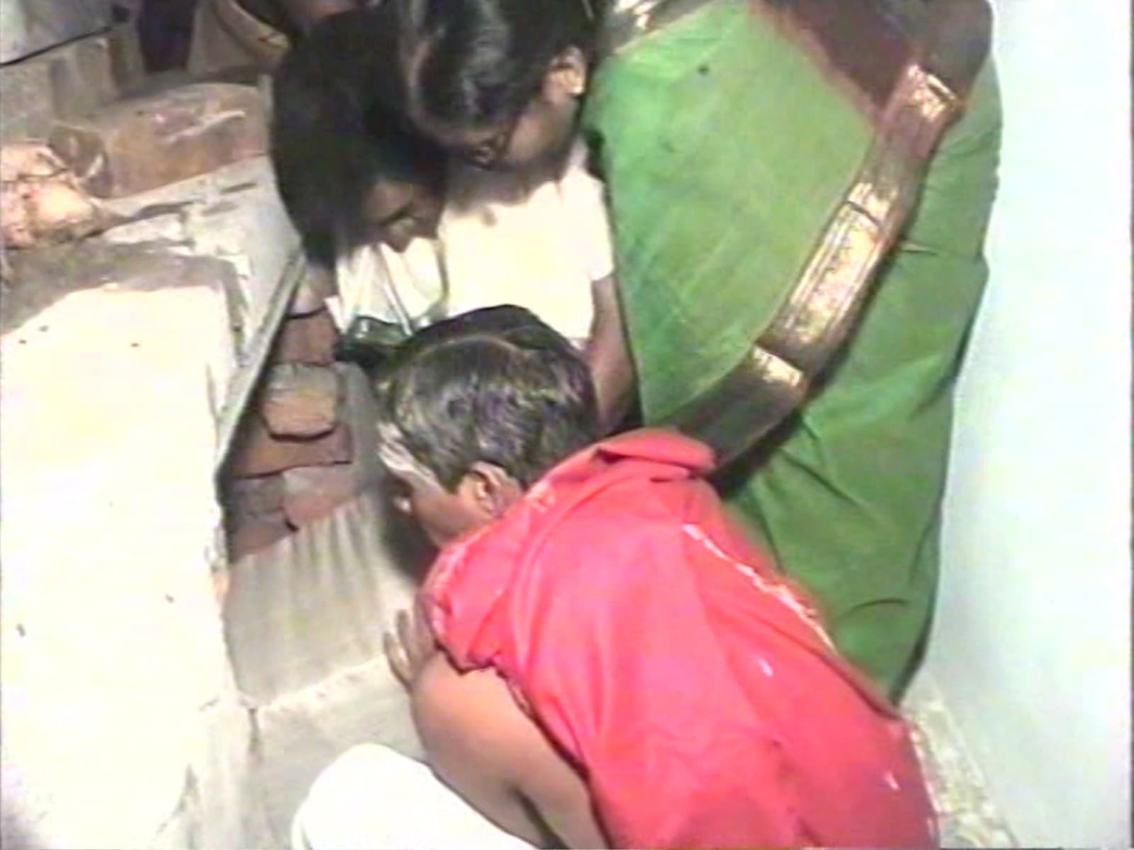 Archival 1997 photo of devotees looking into an opening in the altar during the consecration ceremony
