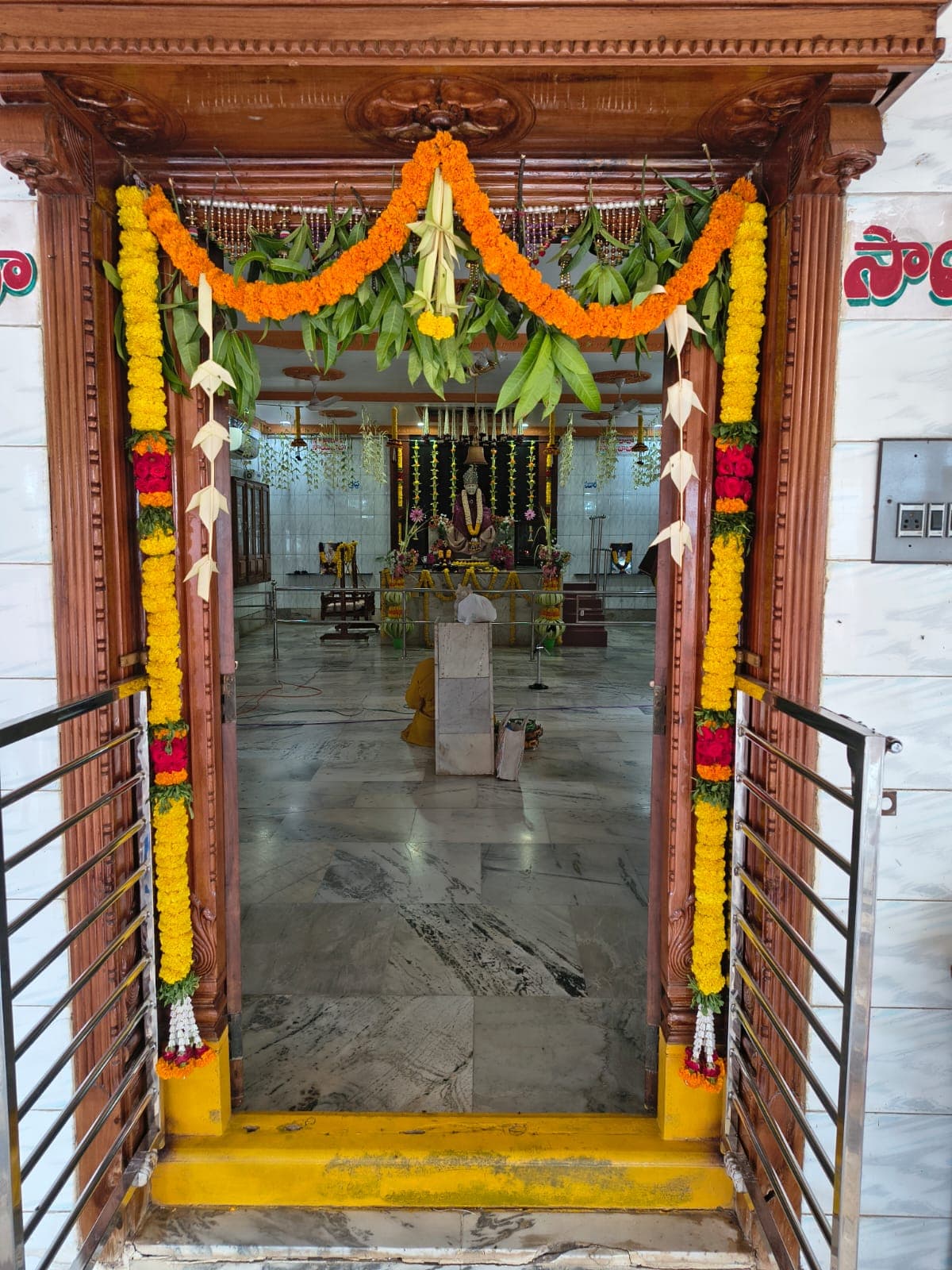 The temple's garlanded entrance doorway, the sanctum visible beyond